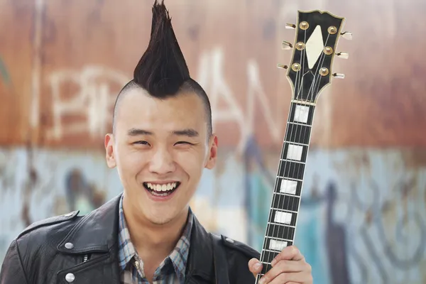 Man med punk mohawk anläggning gitarr — Stockfoto