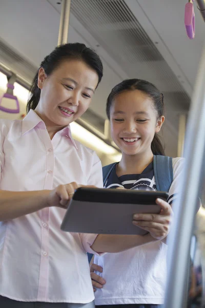 Mather and daughter watching a movie in the subway — Stock Photo, Image