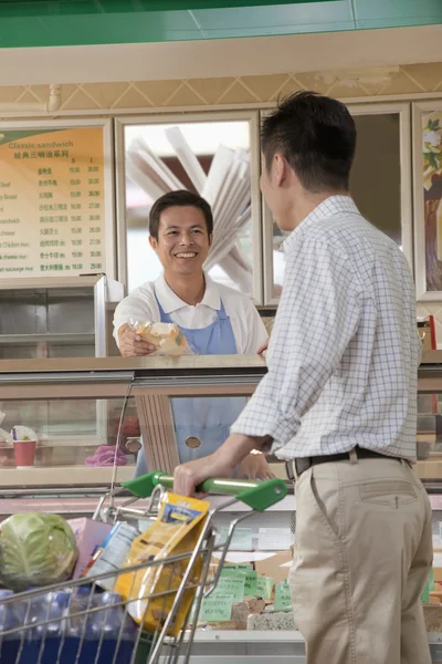 Sales Clerk assisting man at the Deli counter — Stock Photo, Image