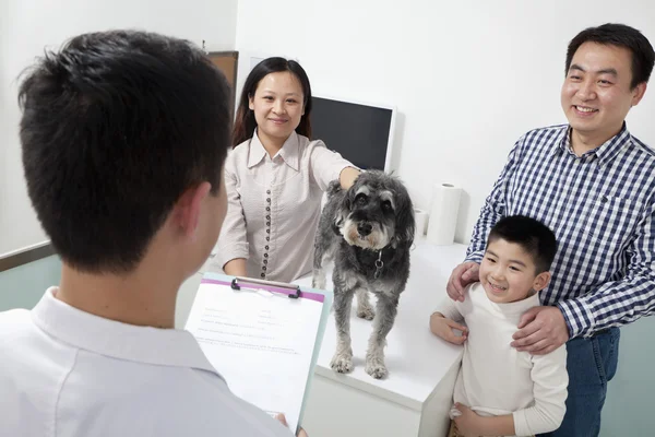 Família com cão de estimação no escritório do veterinário — Fotografia de Stock