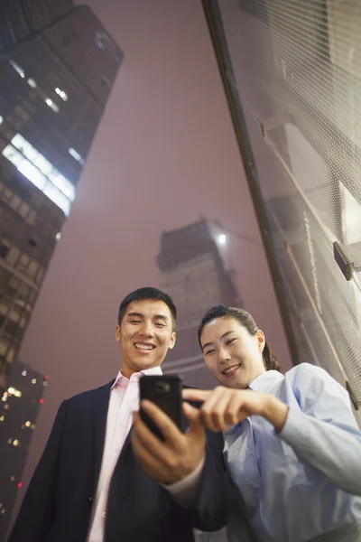 Dos hombres de negocios mirando el teléfono — Foto de Stock