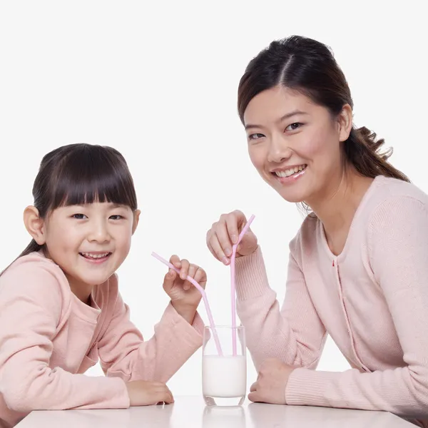 Anne ve kızı bir bardak süt paylaşımı — Stok fotoğraf