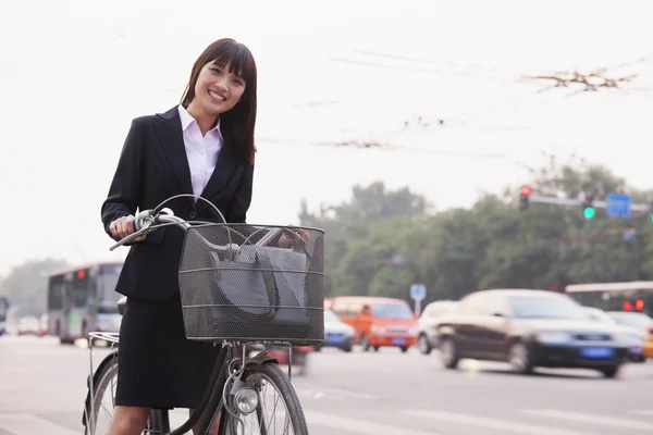Businesswoman riding a bicycle — Stock Photo, Image