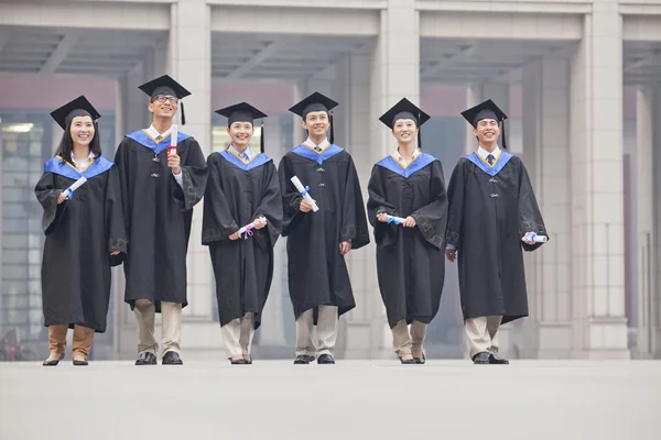 Studenti laureati in piedi con diplomi — Foto Stock