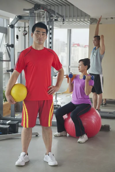 Ung man håller bollen i gymmet — Stockfoto