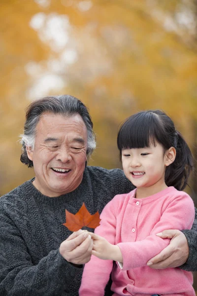 Grandfather and granddaughter in park — Stock Photo, Image