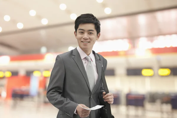 Podnikatel drží letenku na letišti — Stock fotografie