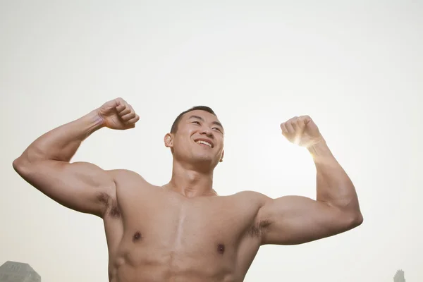 Joven hombre flexión músculos — Foto de Stock