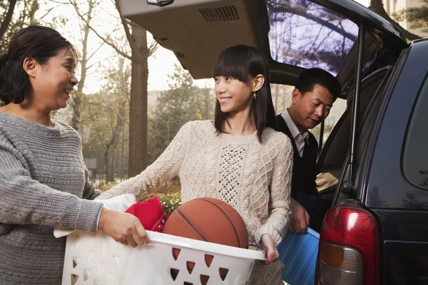 Mother helping daughter unpack car for college — Stock Photo, Image