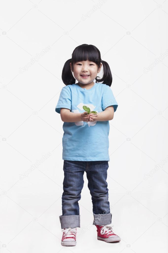 Girl standing and holding a seedling