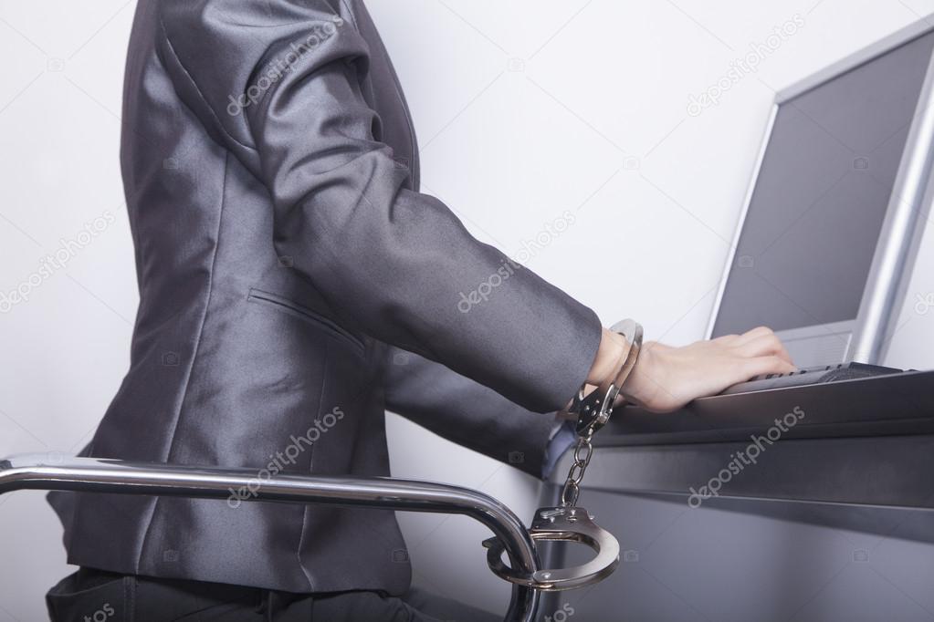 Businesswoman handcuffed to her office chair