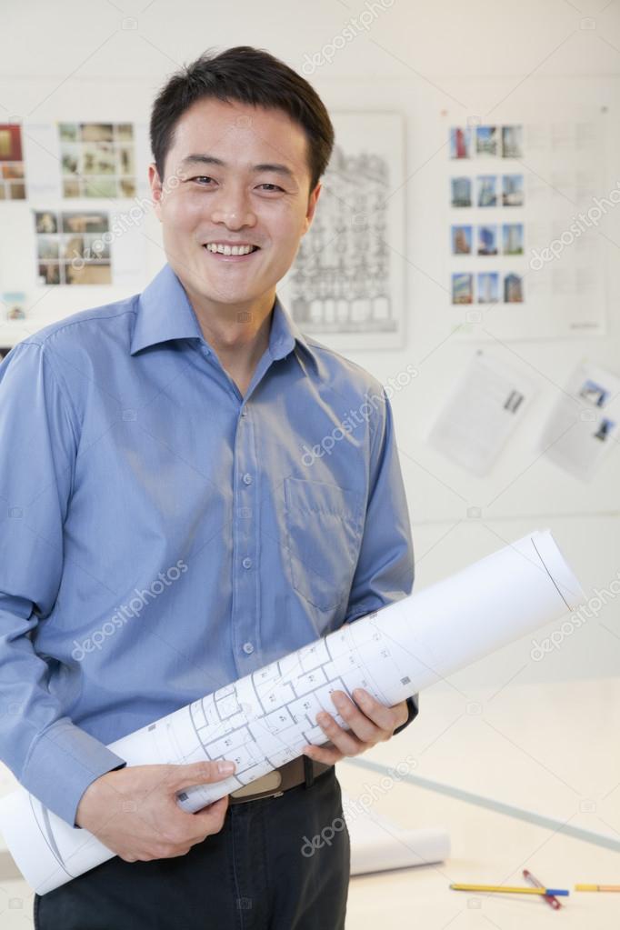 Businessman standing with stuck of papers in the office