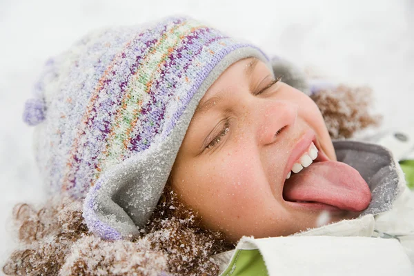 Meisje in sneeuw tong uitsteekt — Stockfoto