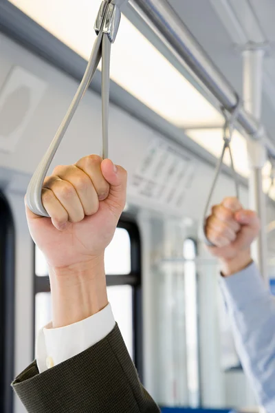 Pessoas segurando alças no trem — Fotografia de Stock