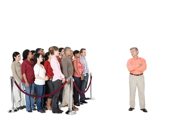 Mature man standing out from the crowd — Stock Photo, Image