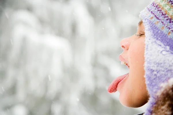 Ragazza nella neve sporgente lingua — Foto Stock