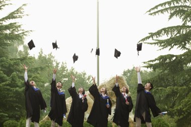 Grup üniversite mezunlarının mortarboards atma