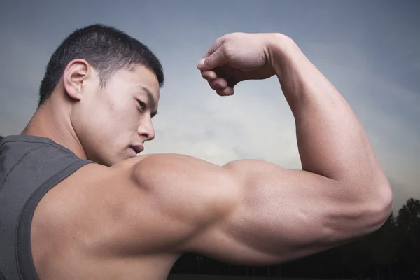 Man pronken zijn biceps spieren — Stockfoto