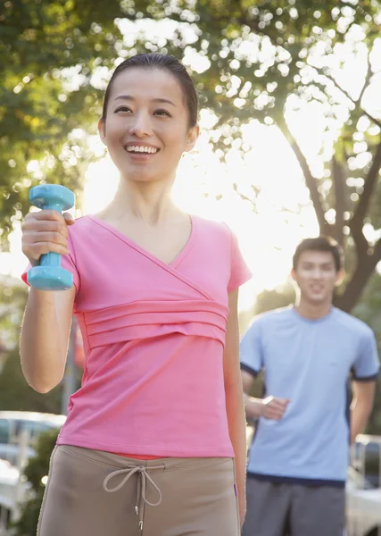 Mujer haciendo ejercicio en el parque con mancuernas — Foto de Stock