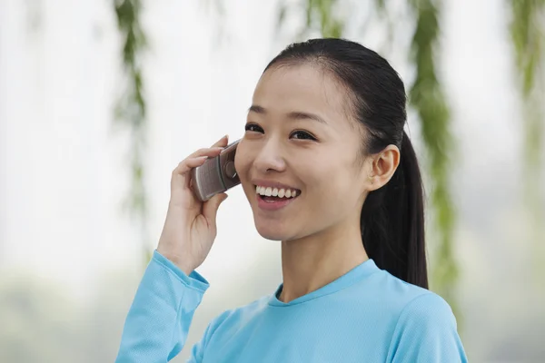 Vrouw praten op mobiele telefoon in het park — Stockfoto