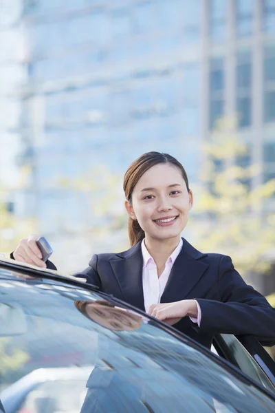 Affärskvinna stående med bil — Stockfoto