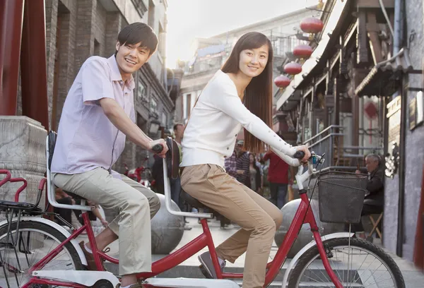 Pareja en una bicicleta tándem en Beijing mirando a la cámara — Foto de Stock