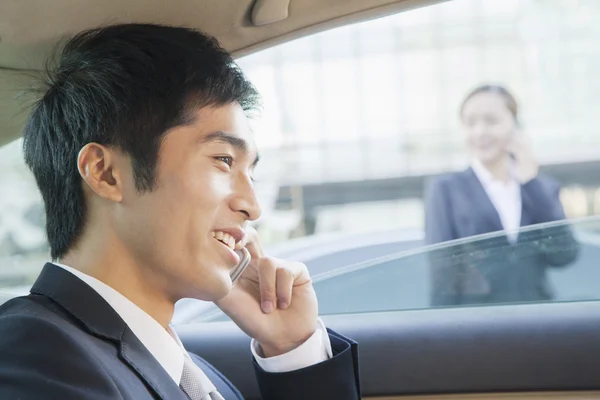 Homme d'affaires dans le siège arrière de la voiture au téléphone — Photo