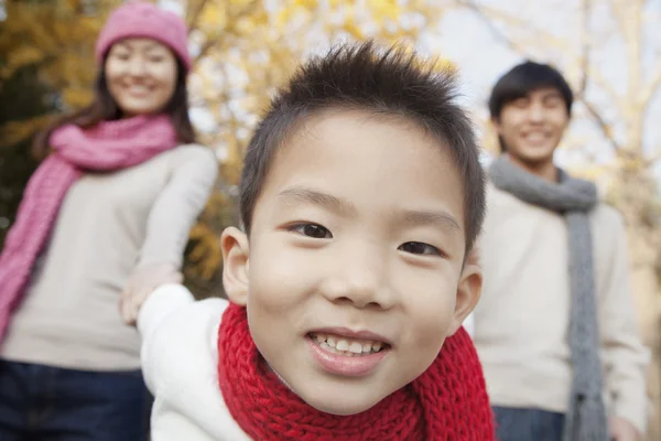 Мальчик с семьей в парке осенью — стоковое фото