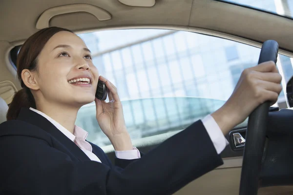Affärskvinna körning och på telefonen — Stockfoto