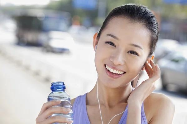 Nő, palackozott víz zene hallgatása — Stock Fotó