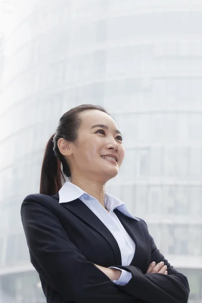 Mujer de negocios mirando hacia arriba en el entorno urbano — Foto de Stock