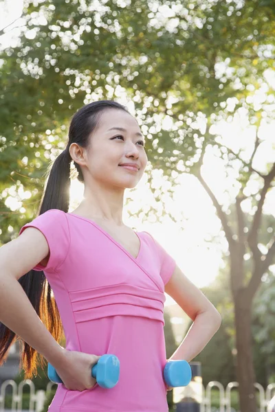 Femme s'exerçant dans le parc avec des haltères — Photo