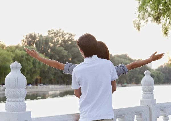 Couple with Arms Outstretched by a Lake — Stock Photo, Image