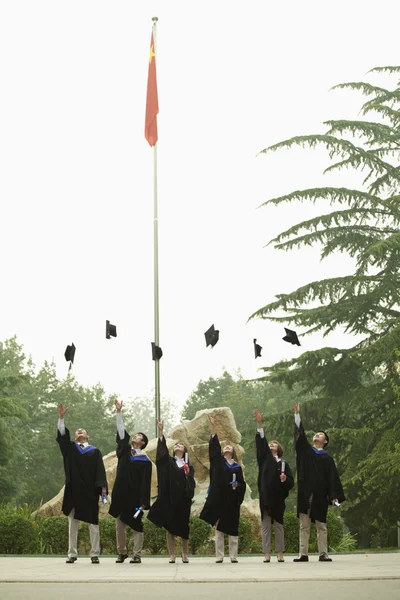 Üniversite mezunları mortarboards atma — Stok fotoğraf