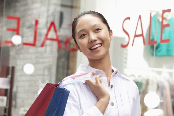 Kvinna shopping framför försäljning tecken — Stockfoto