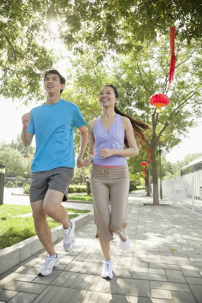 一对年轻夫妇在公园里奔跑 — 图库照片