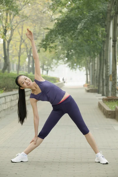 Woman stretching in the park — Stock Photo, Image