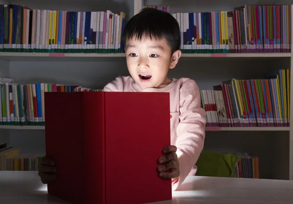 Chłopak zaskoczony przez świecące książki — Zdjęcie stockowe