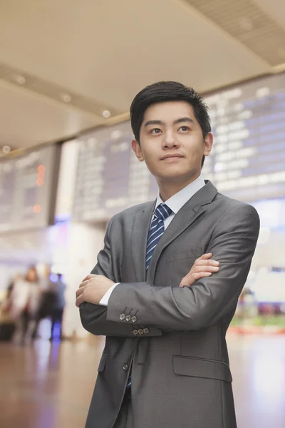 Podnikatel s rukama zkříženýma na letišti — Stock fotografie