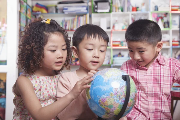 Estudantes a olhar para um globo — Fotografia de Stock