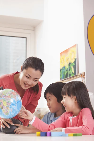 Studenti e insegnanti che guardano Globe — Foto Stock