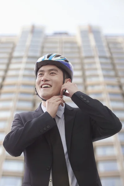 Businessman putting on cycling helmet — Stock Photo, Image