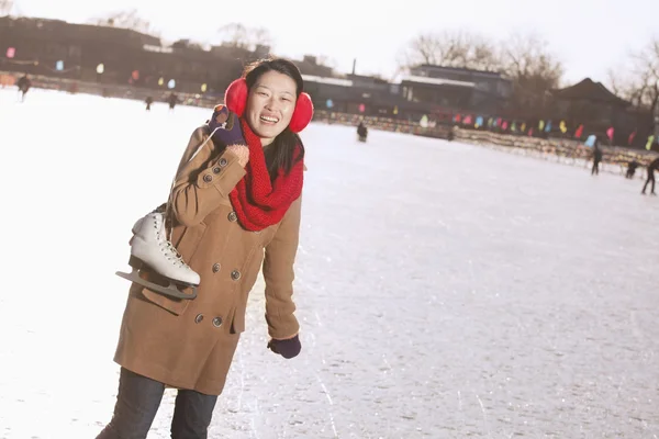 Woman Holding Up Ice Skates Outside — Stock Photo, Image