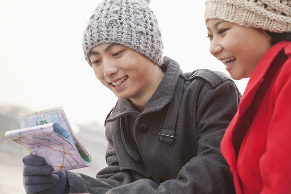 People looking at map outside in winter — Stock Photo, Image