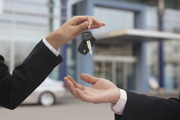 Salesman handing over car keys — Stock Photo, Image