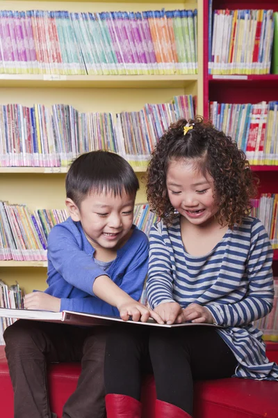 Menino e menina lendo juntos — Fotografia de Stock