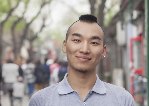 Jeune homme avec coupe de cheveux mohawk souriant — Photo