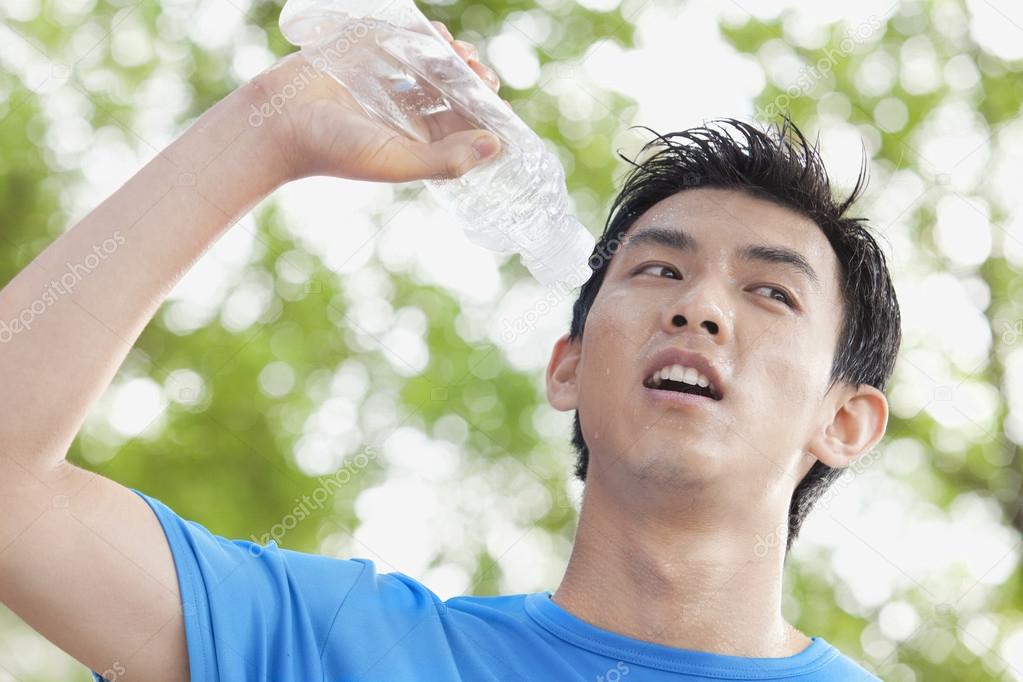 Man Drinking Bottled Water in Park