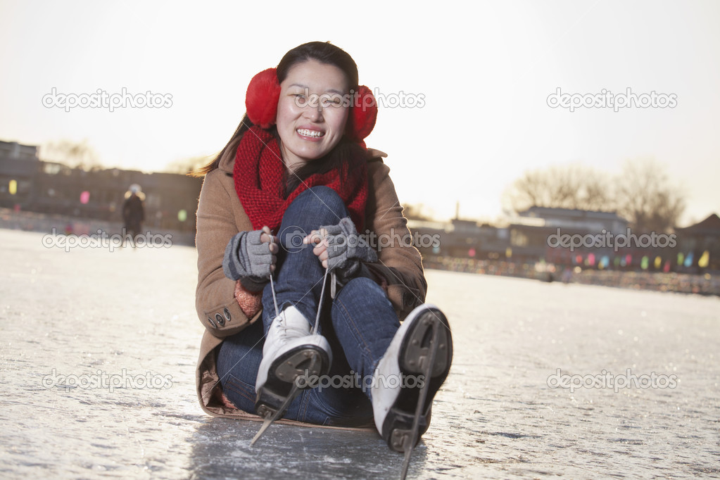 Woman Tying Ice Skates Outside
