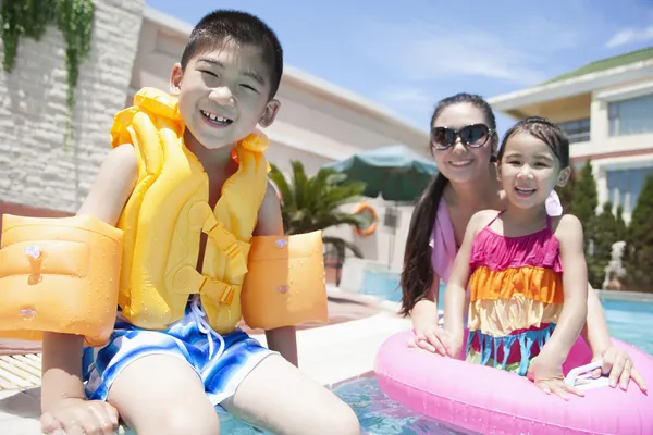 Familia junto a la piscina con juguetes de piscina —  Fotos de Stock